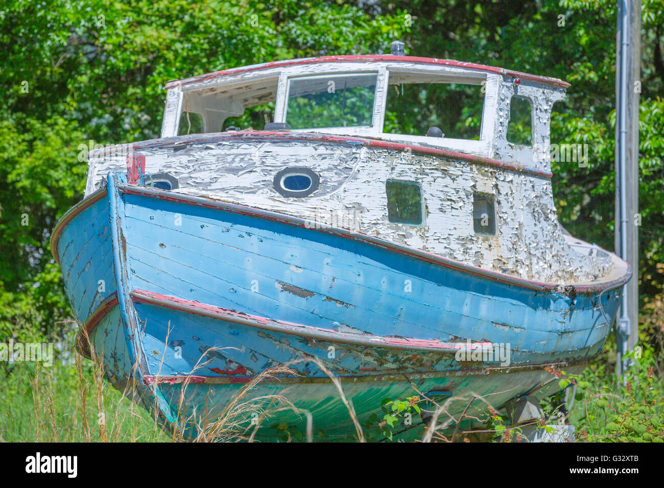 Una vecchia imbarcazione in legno, sul blocco in un cattivo stato di manutenzione Foto Stock