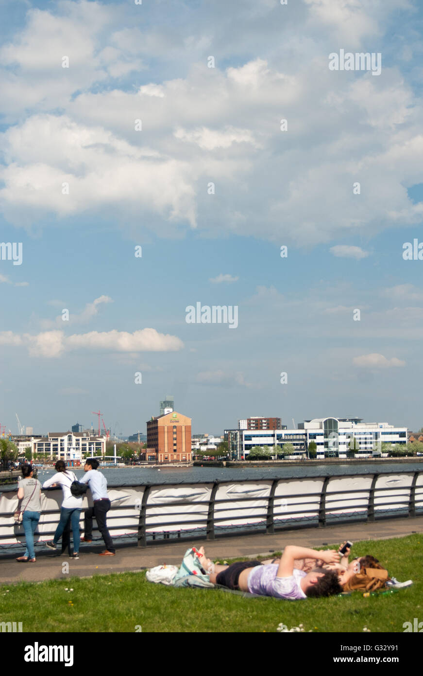 Giovani godendo il sole a Salford Quays, Manchester Foto Stock