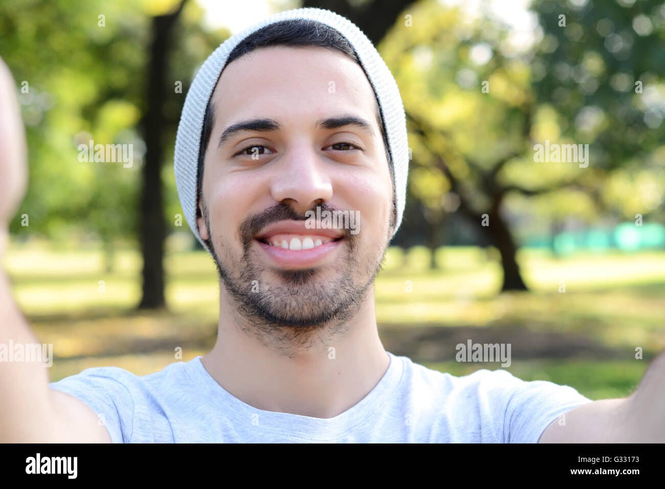 Giovane uomo latino tenendo un selfie in un parco. All'esterno. Foto Stock