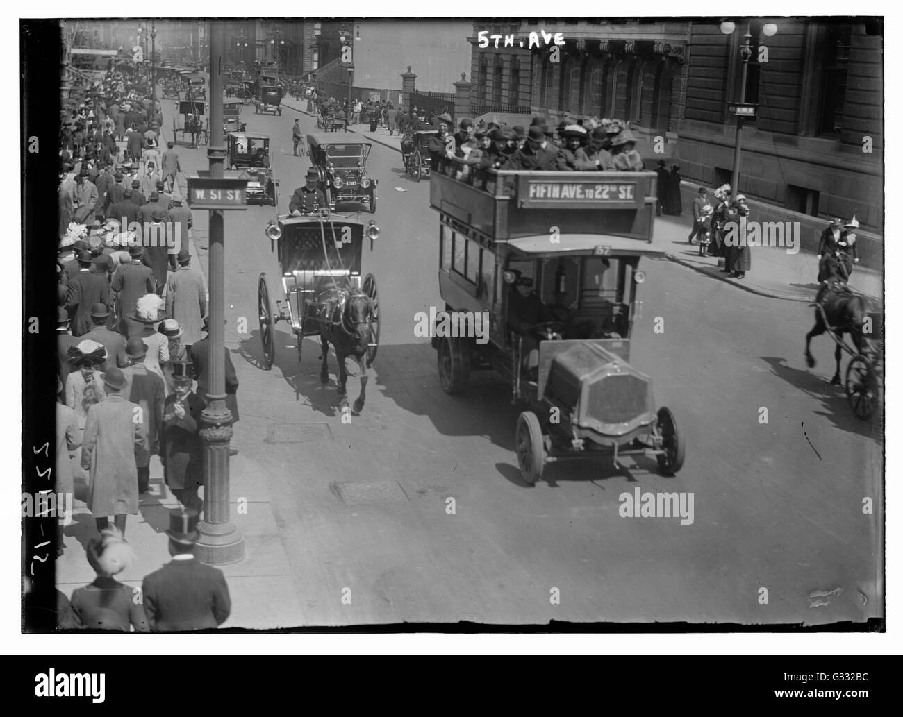 Vista, guardando a Nord, dell'angolo di West 51st Street e la Fifth Avenue, che mostra strade affollate con pedoni e automobili. Carrozze trainate da cavalli e le auto condividono la strada. Foto Stock