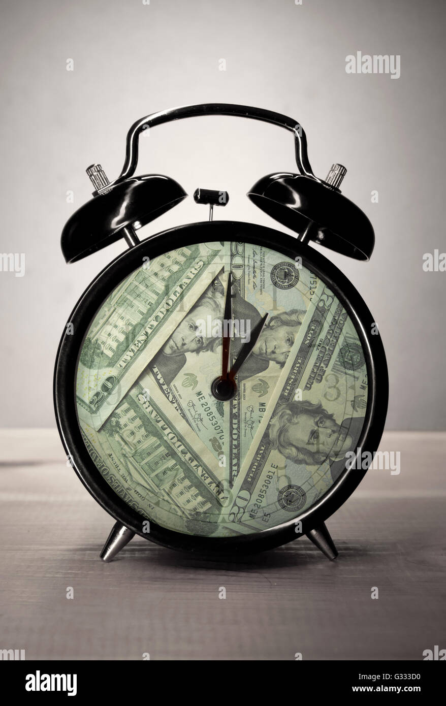 Orologio sveglia con banconote di dollari all'interno il tempo è denaro concept Foto Stock