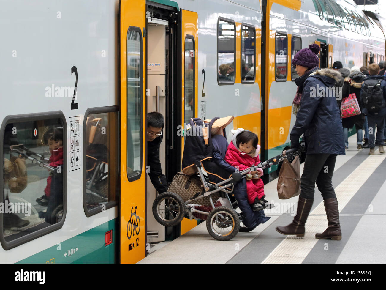 Berlino, Germania, i genitori sollevare un bambino trasporto in un treno di ODEG Foto Stock