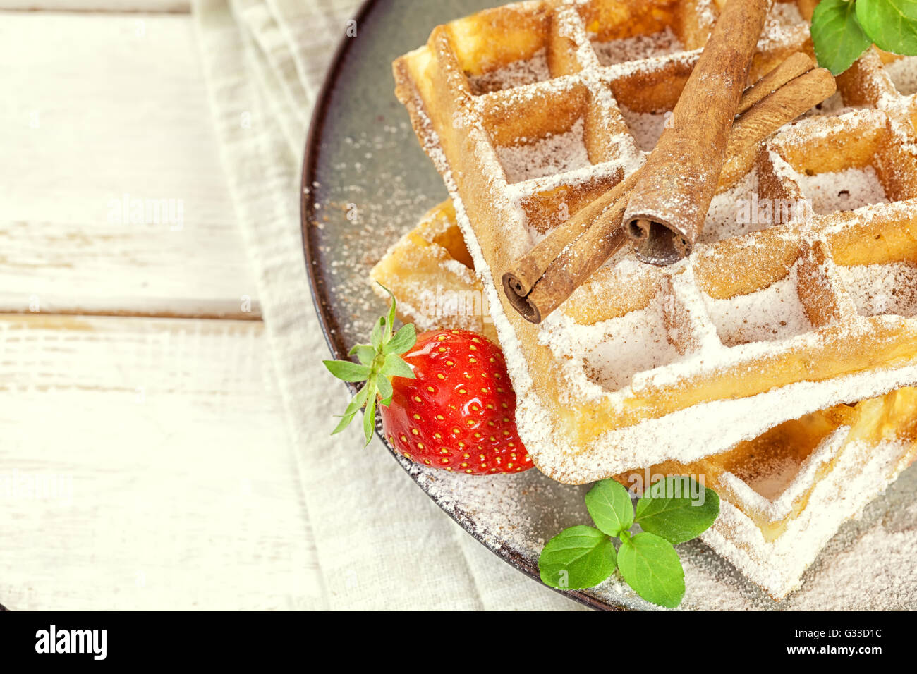 Cialde belghe con fragole fresche e bastoncini di cannella Foto Stock