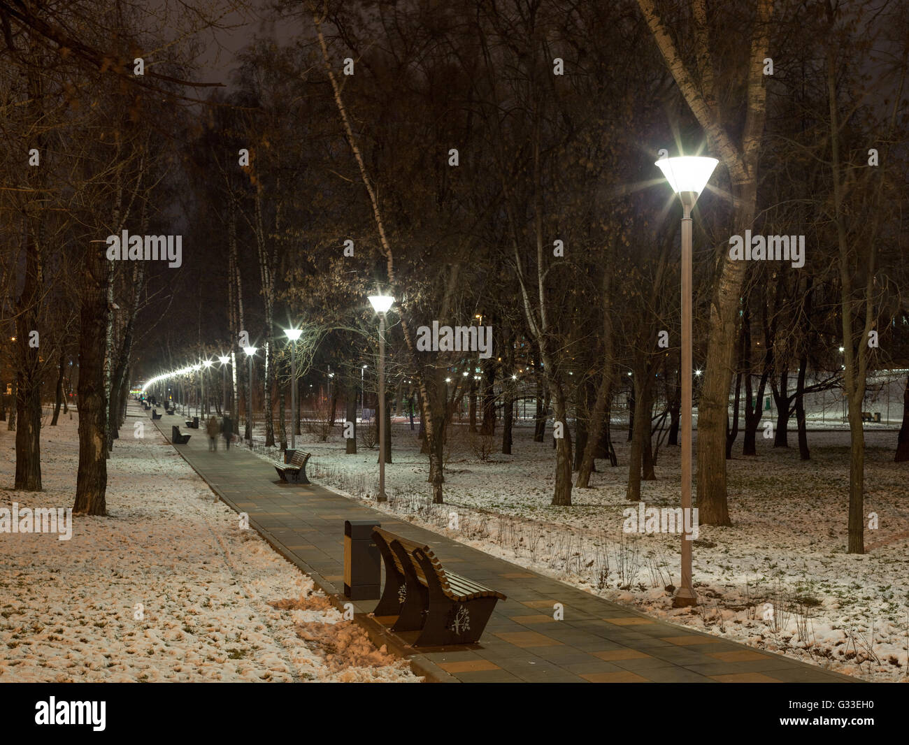 Illuminazione serale in inverno urban. Lunga passerella con lampade di via. Luci della città e di illuminatori. Russia, Mosca. Foto Stock