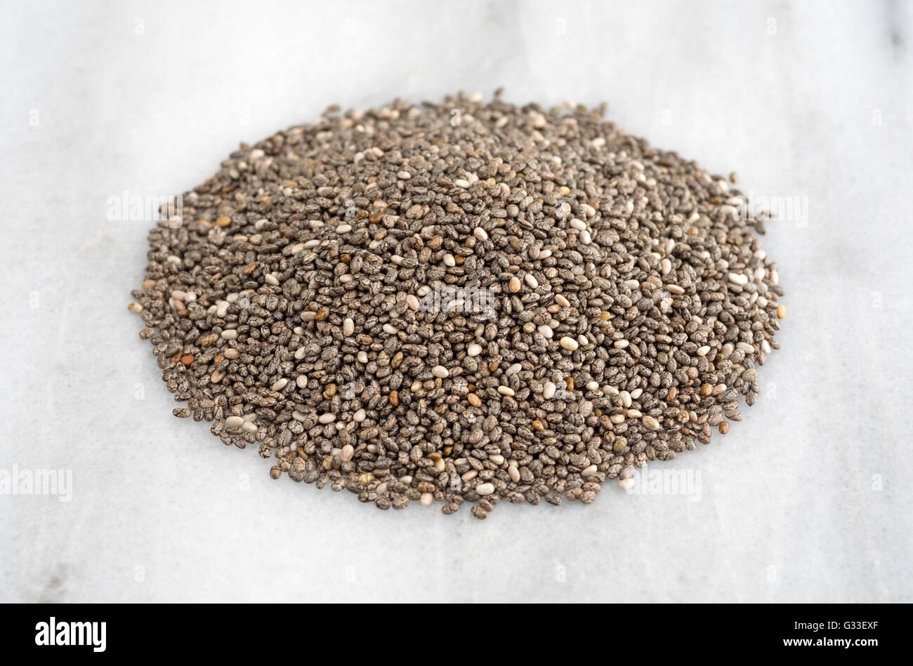 Una porzione di organico chia semi sul marmo di un tagliere. Foto Stock