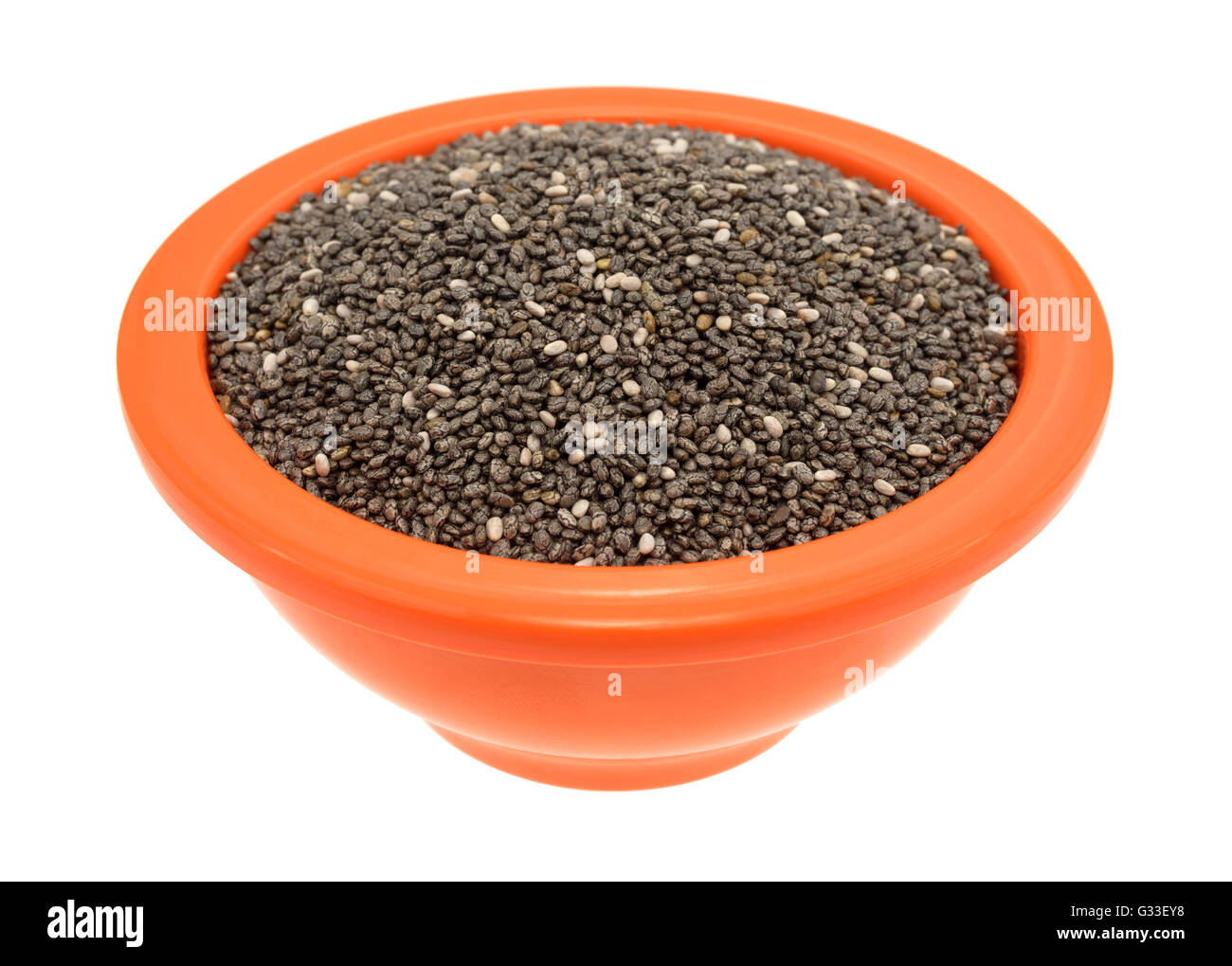 Vista laterale di un arancio ciotola riempita con organici semi di chia isolato su uno sfondo bianco. Foto Stock