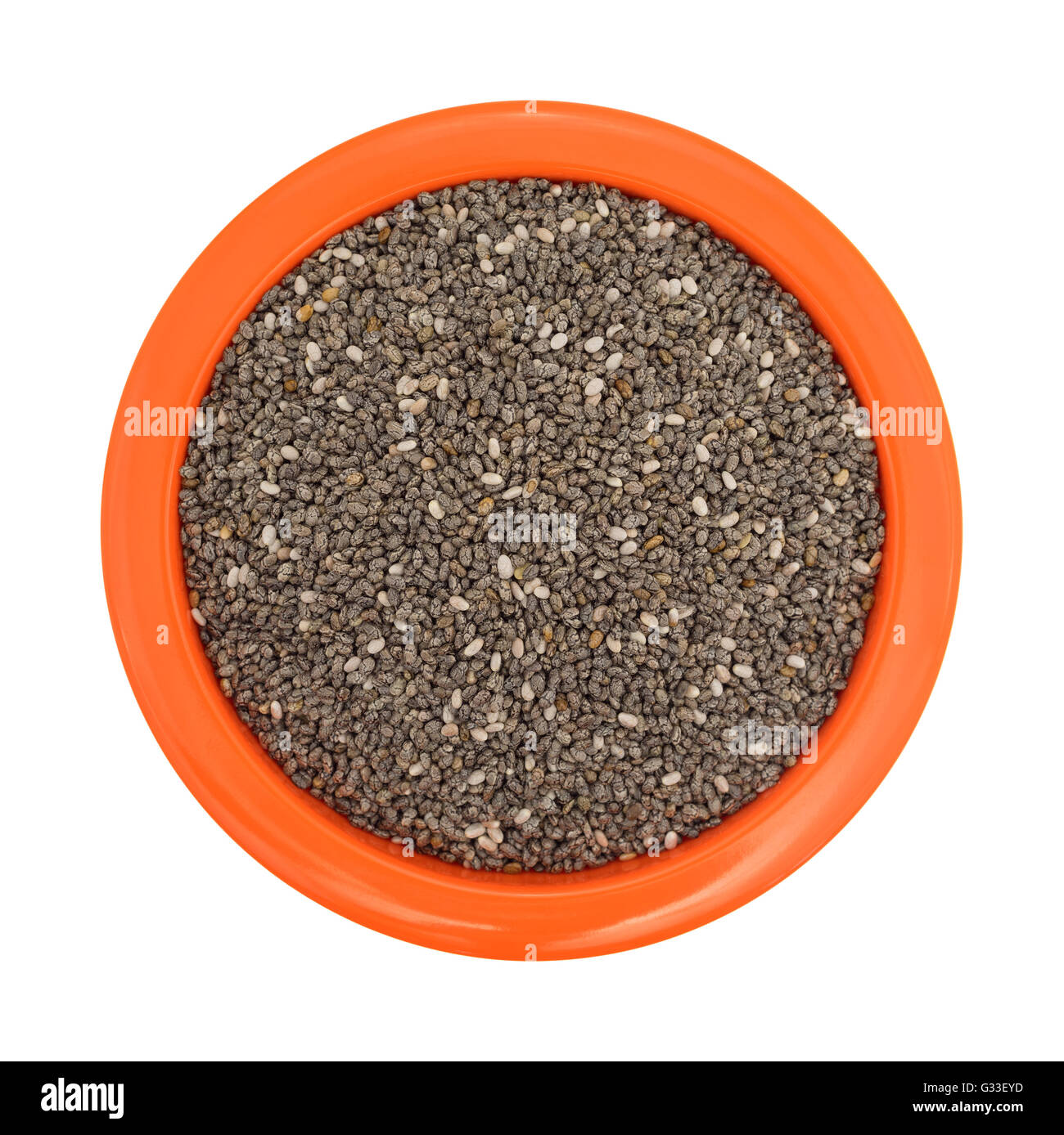 Vista dall'alto di un arancio ciotola riempita con organici semi di chia isolato su uno sfondo bianco. Foto Stock