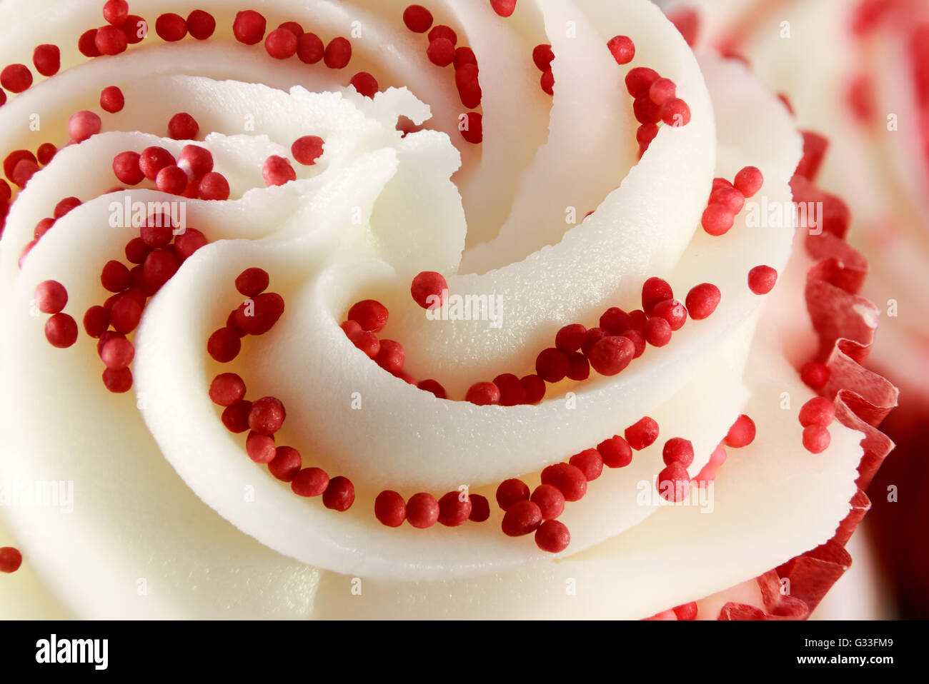 Primo piano della Red Velvet cupcake decorate con roteato glassa di zucchero e perle Foto Stock