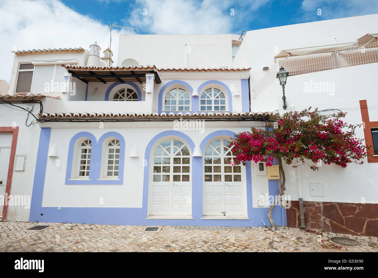 La facciata della tipica casa Algarve con fiori, Portogallo Foto Stock