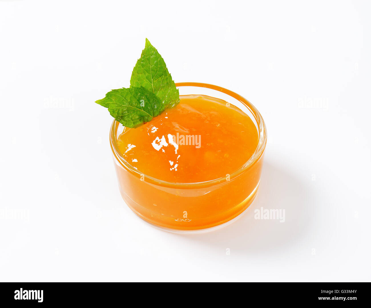 Tazza di confettura di albicocche su sfondo bianco Foto Stock