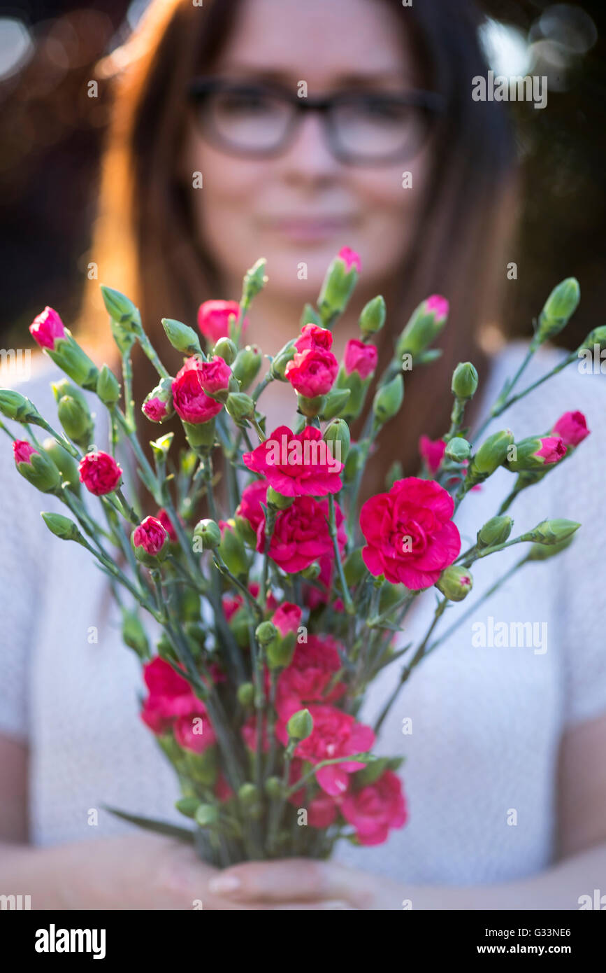Una foto di una giovane donna con un mazzo di fiori Foto Stock