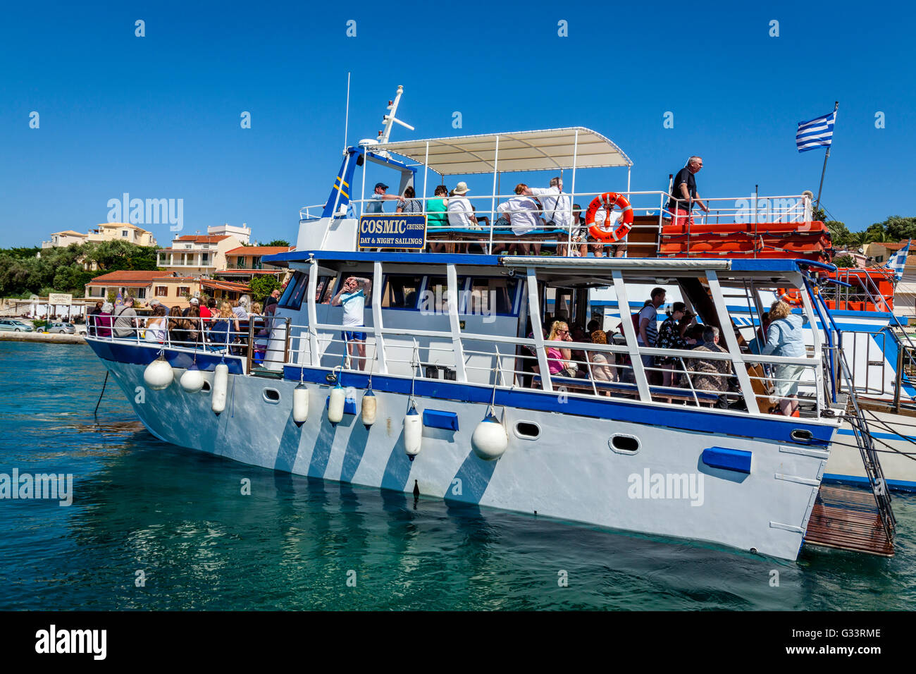 I turisti arrivano in barca presso la località balneare di Kassiopi, l'isola di Corfù, Grecia Foto Stock