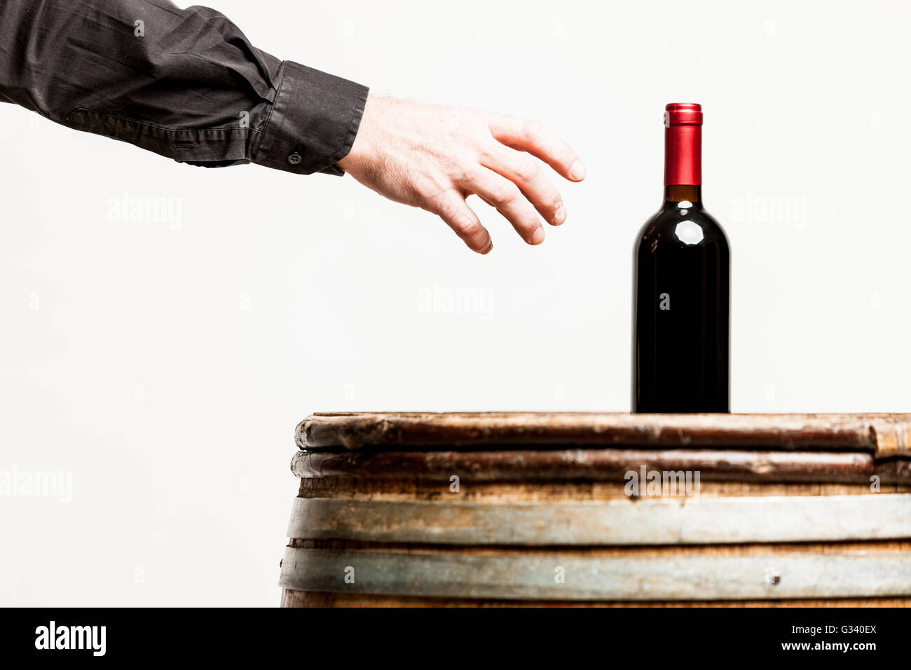 Maschio su mano per afferrare una bottiglia di vino Foto Stock