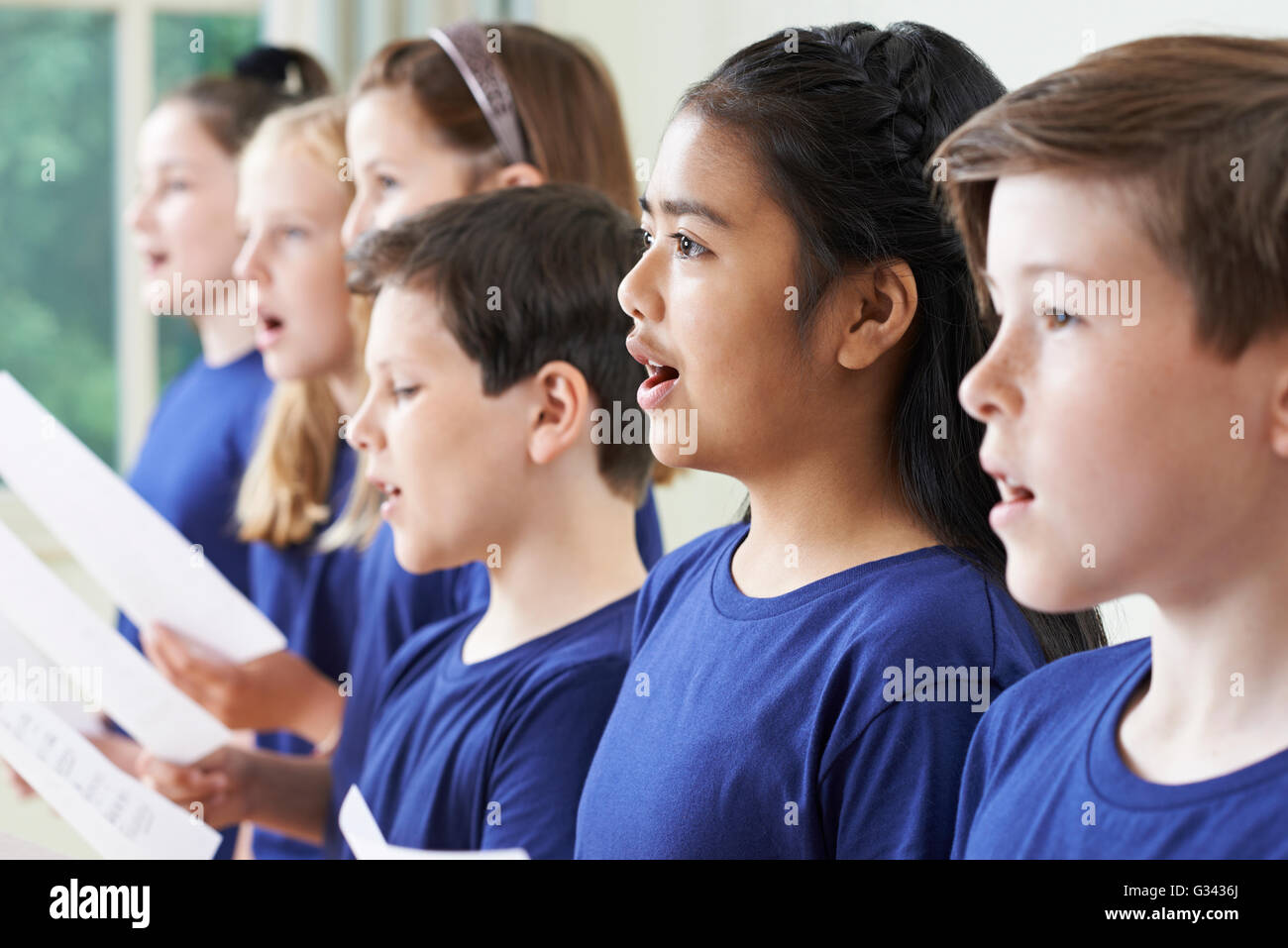Un gruppo di bambini della scuola di cantare in coro insieme Foto Stock