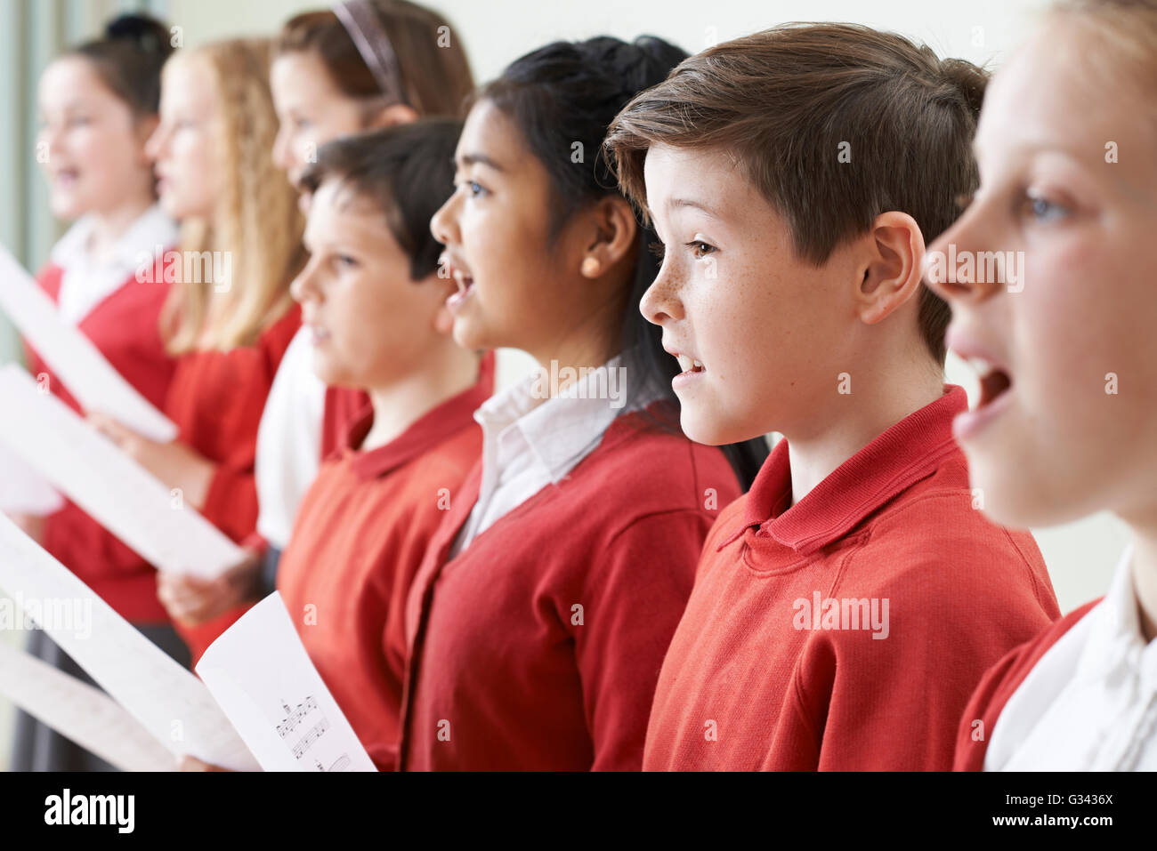 Gruppo di bambini a cantare in coro scolastico Foto Stock