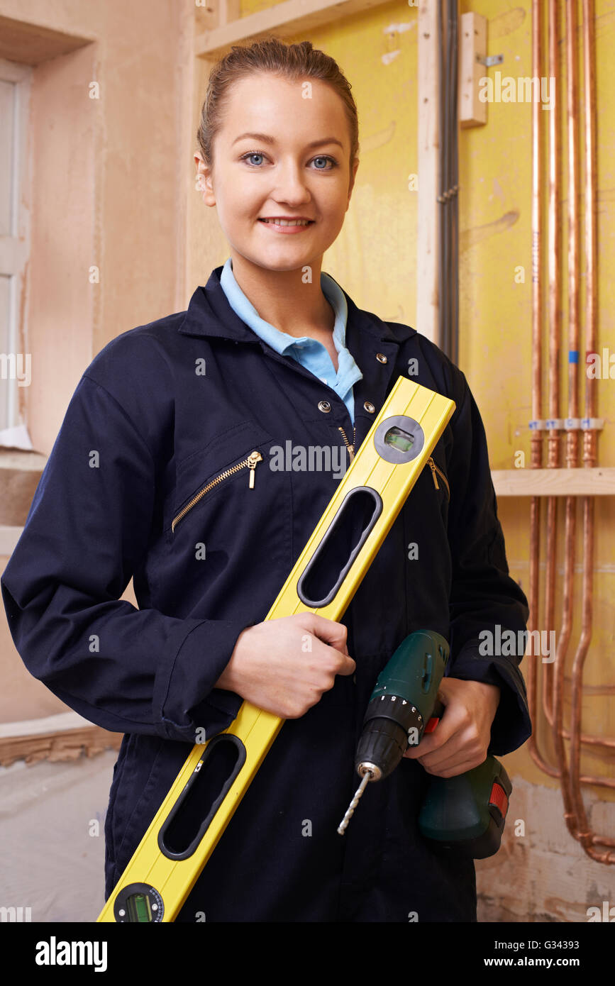 Ritratto di donna Builder con bolla di livello e un trapano elettrico Foto Stock
