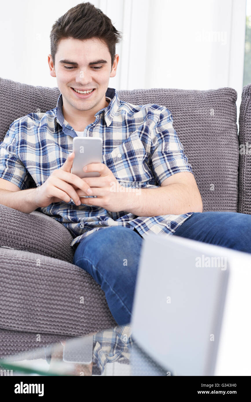 L'uomo streaming di musica dal telefono cellulare per altoparlante senza fili Foto Stock