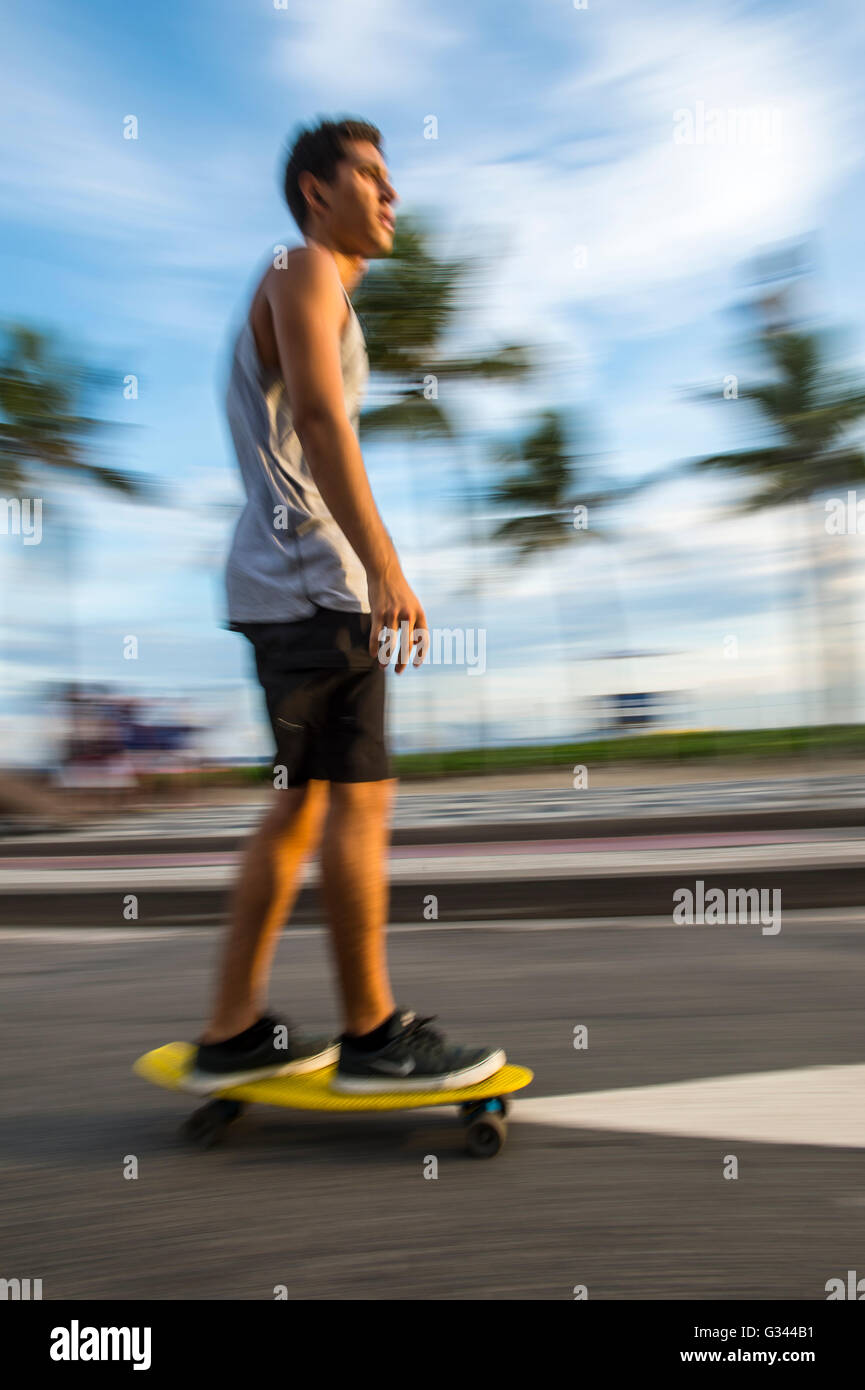 RIO DE JANEIRO - 6 Marzo 2016: il giovane brasiliano carioca uomo su skateboard si muove in una sfocatura di movimento lungo il fronte spiaggia street. Foto Stock