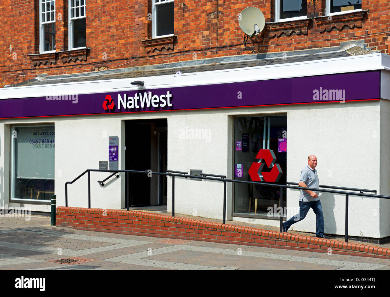 L'uomo lasciando il ramo della Natwest Bank, England Regno Unito Foto Stock