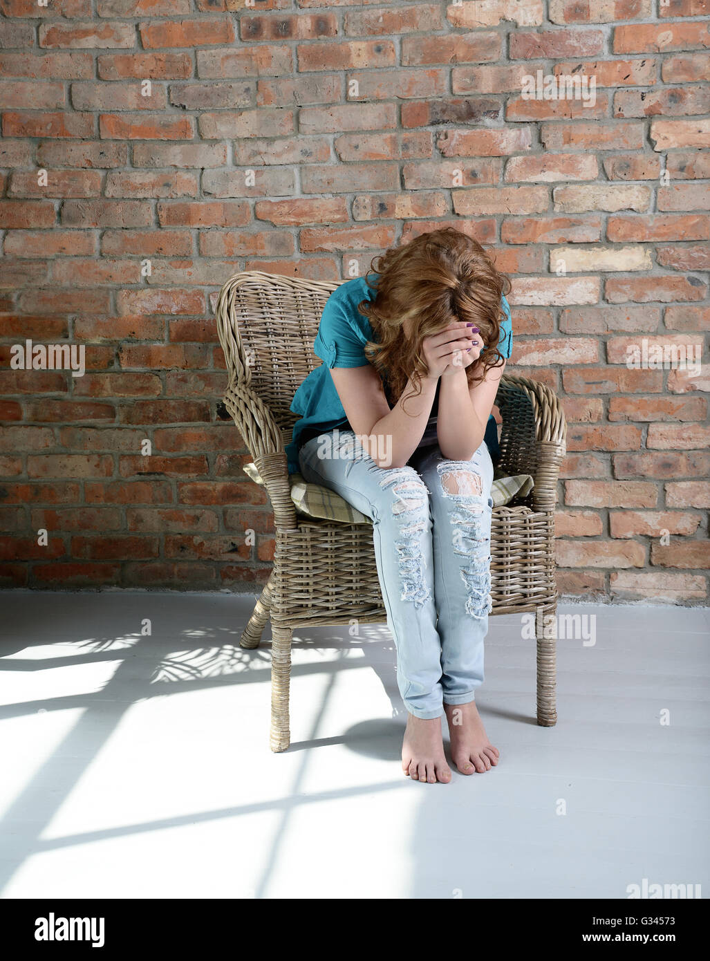Donna seduta sulla sedia in depressione Foto Stock
