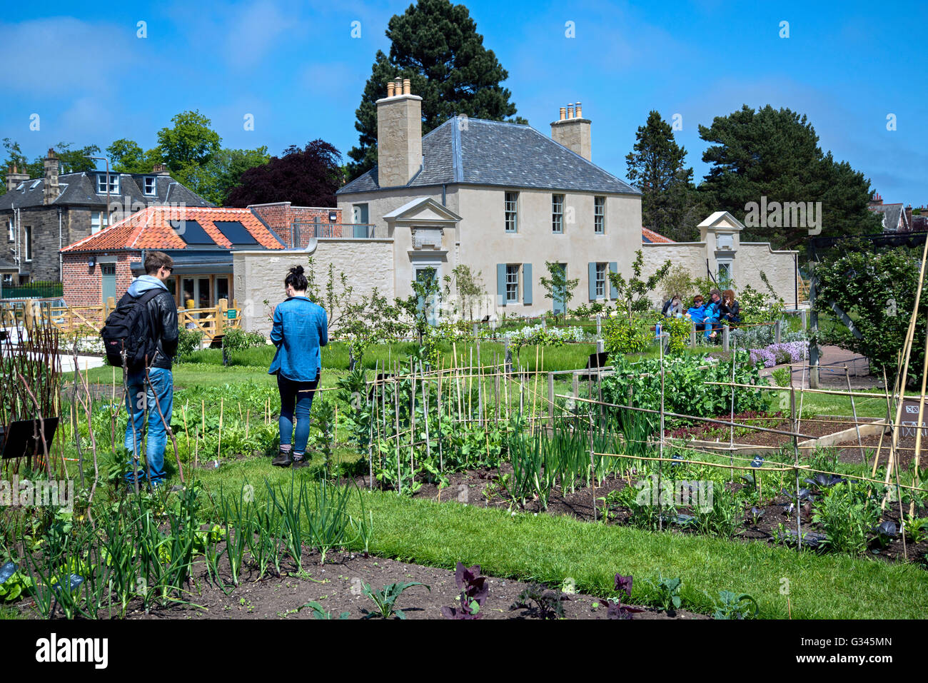 I visitatori del Royal Botanic Gardens in Edinburgh ispezionare le erbe e orti con il Botanic Cottage in background. Foto Stock