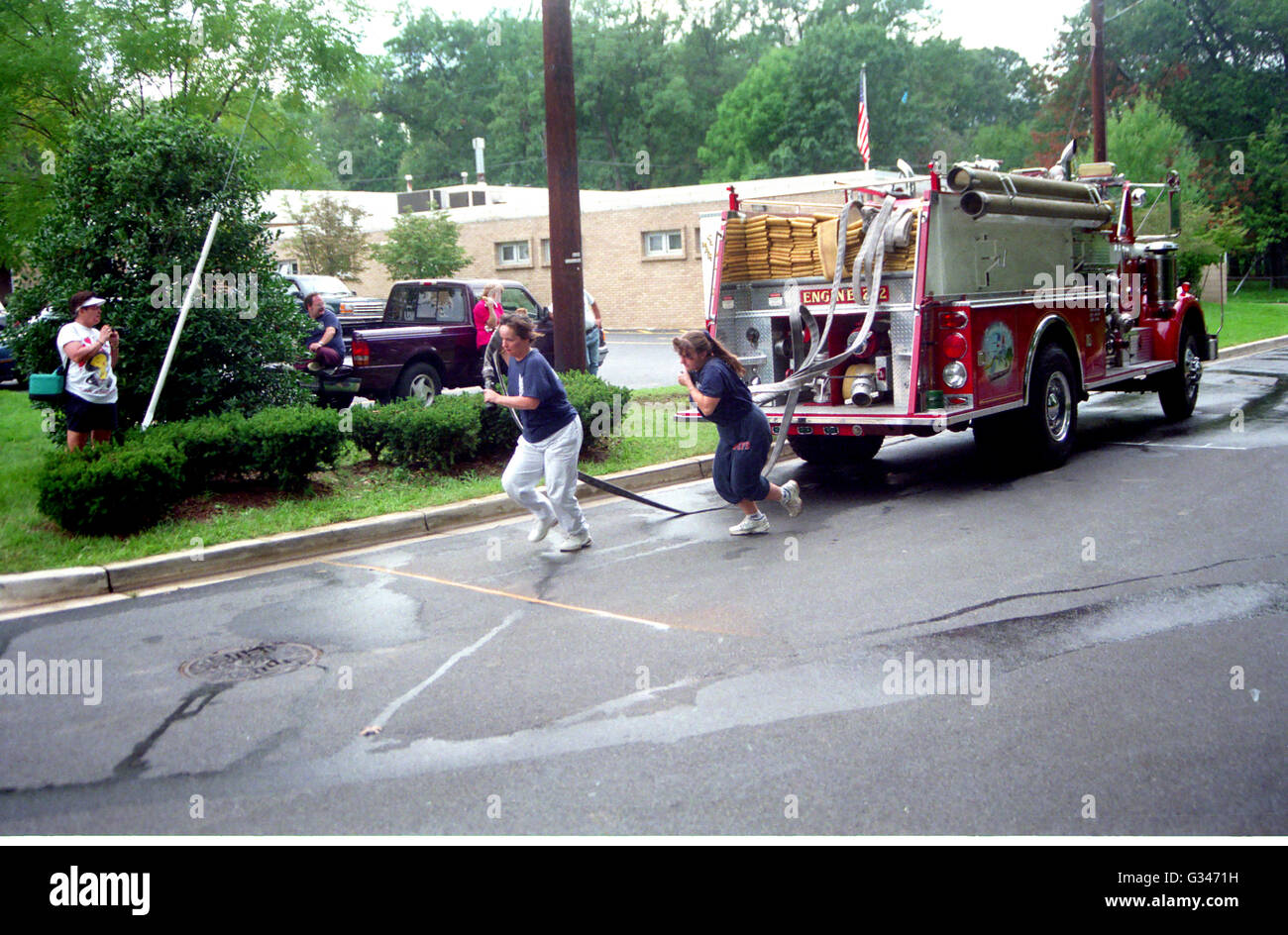 Membri del Clinton Volunteer Fire Dept il signore partecipa ausiliario in un reparto antincendio gioco flessibile di trascinamento di un idrante Foto Stock