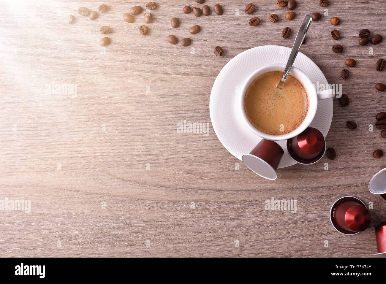 Tazza di caffè espresso servito con cialde e capsule su marrone tavolo in legno e lucentezza. Vista superiore Foto Stock