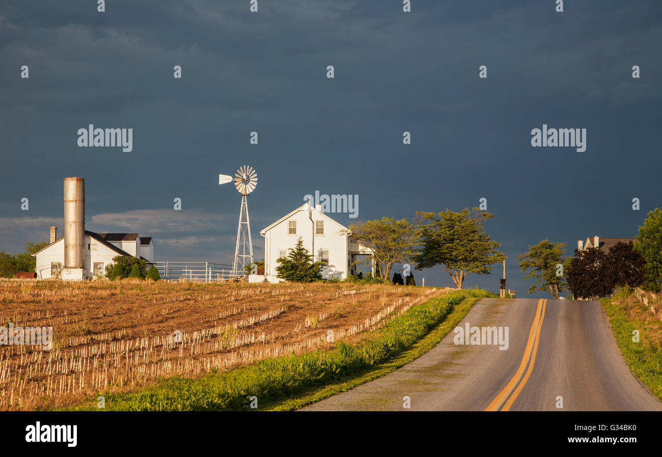 Bianco fattoria paesaggio con un cielo tempestoso nella campagna Amish della contea di Lancaster, Pennsylvania rurale, Stati Uniti, Stati Uniti, percorso casa di campagna silo campo Foto Stock