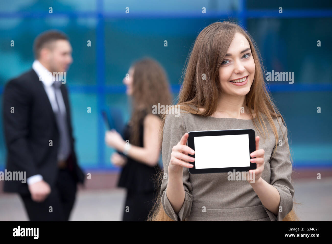Ritratto di fiducioso giovane donna azienda tablet con vuoto bianco spazio copia schermo e guardando la telecamera con il viso felice Foto Stock