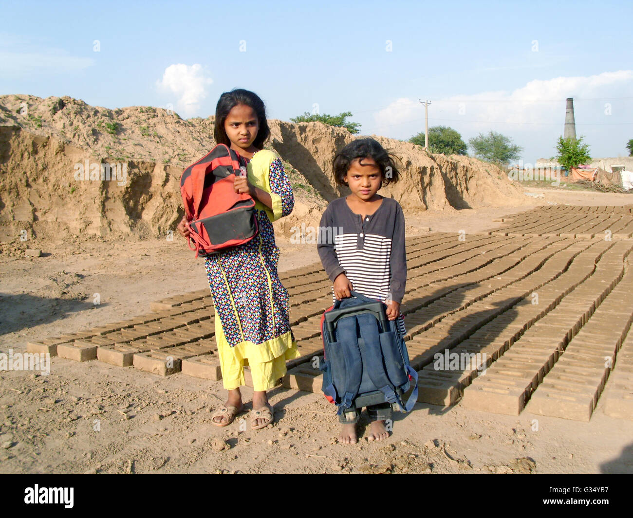 Islamabad, Pakistan. 27 apr, 2016. Sette-anno-vecchia ragazza Manal e cinque-anno-vecchia ragazza Laiba pongono sui terreni di una fornace in un sobborgo di Islamabad, Pakistan, 27 aprile 2016. Le due ragazze lavorare alla fornace dopo la scuola nonostante una nuova legge che vieta il lavoro minorile in Pakistan brickyards. Foto: Sajjad Malik/dpa/Alamy Live News Foto Stock