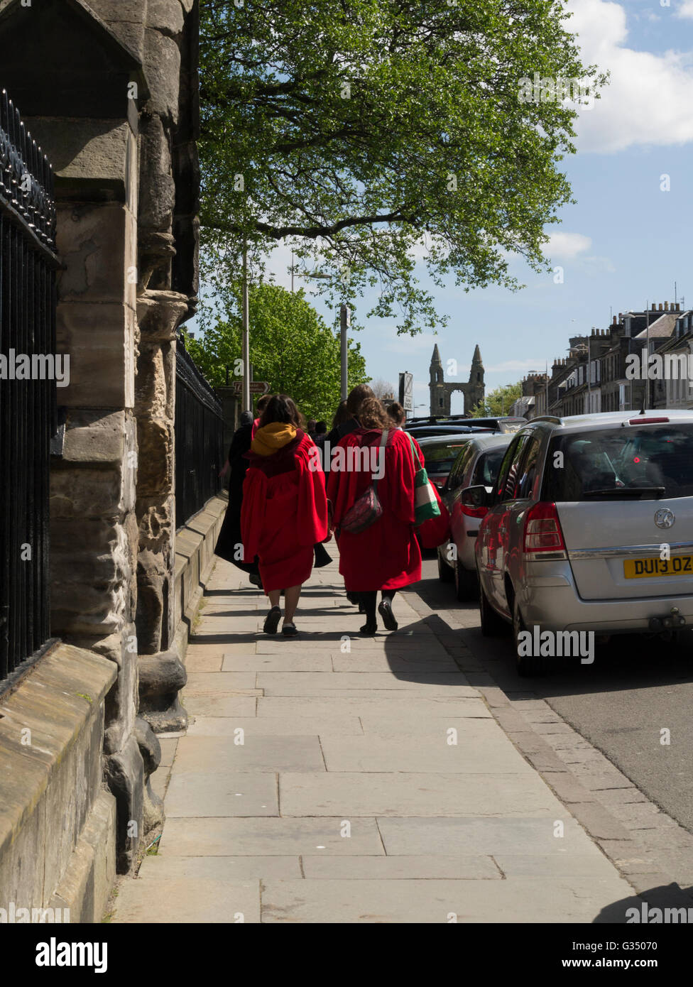 Cantori femmina lasciando San Salvator della Cappella di St Andrews Fife Scozia indossa red cassocks parte della St Andrews University Foto Stock