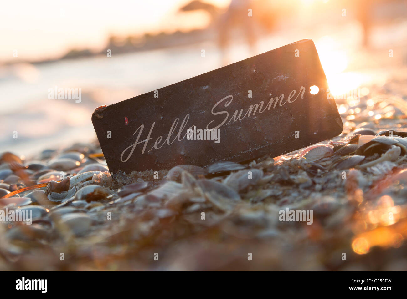 Ciao testo in estate e al tramonto sulla spiaggia. Foto Stock