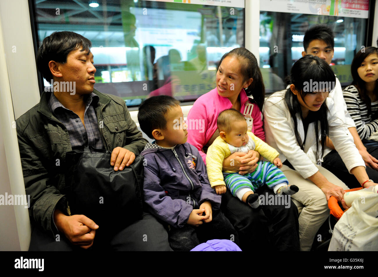 Cina provincia del Guangdong, città di Guangzhou, sistema di trasporti pubblici, Treno metro, familiare del lavoratore migrante Foto Stock