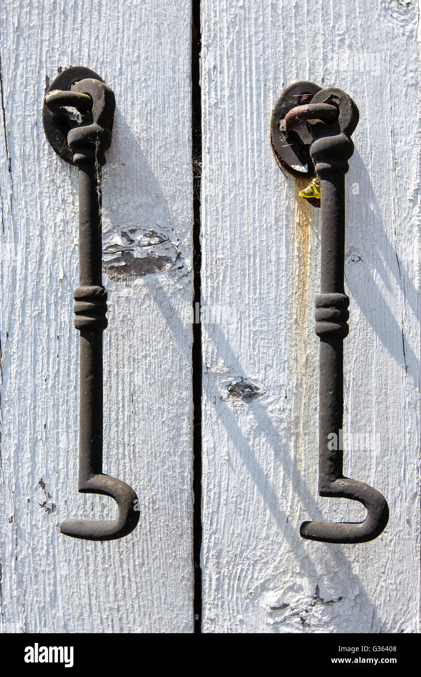 Due ganci di acciaio appeso a un dipinto di bianco in legno del telaio della porta in stretta fino Foto Stock
