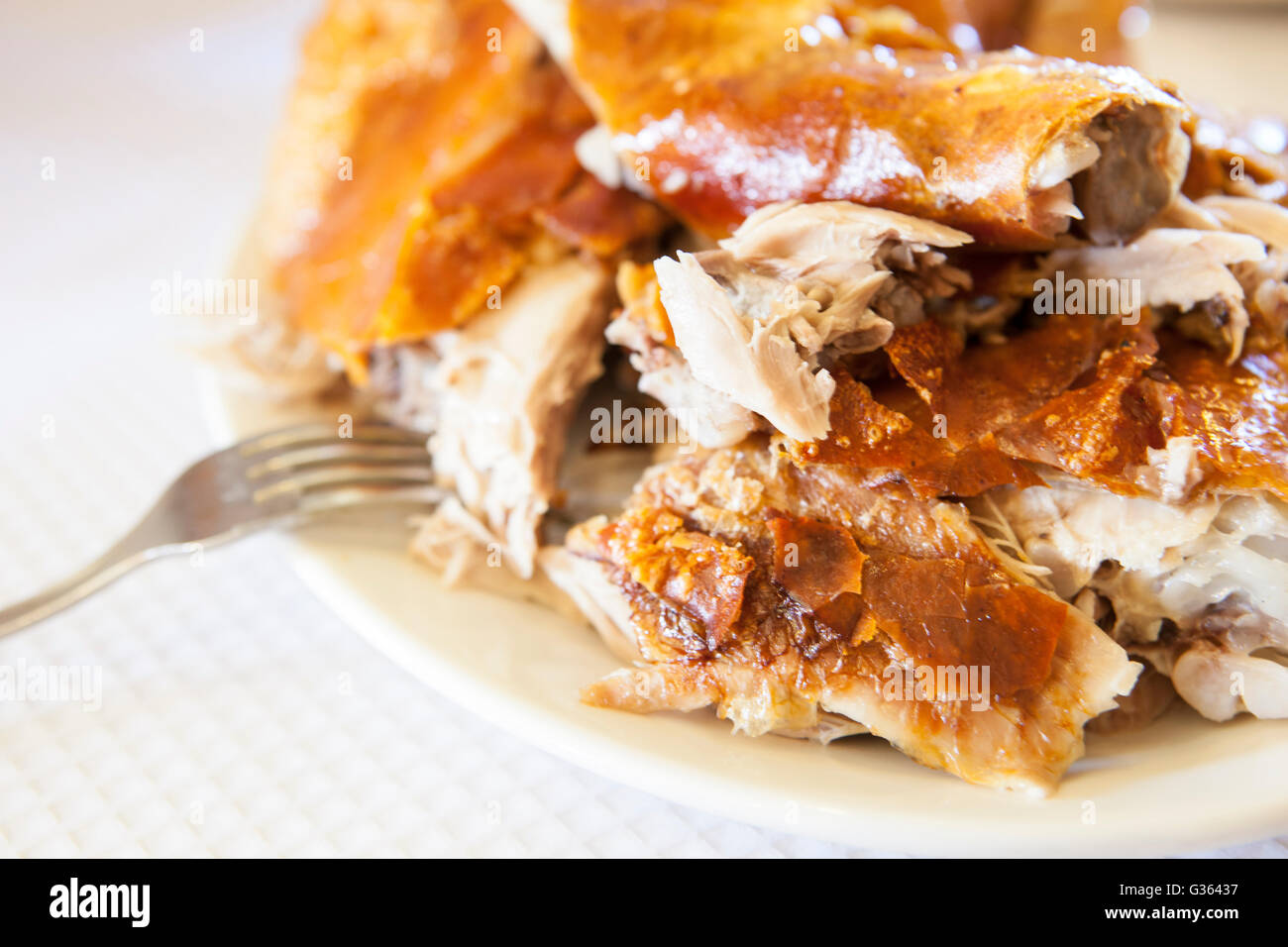 Scorpacciata di arrosto di maiale tagliata in pezzi con la pelle e la forcella Foto Stock
