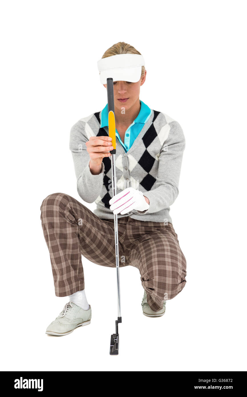 Femmina giocatore di golf inginocchiato con un club di golf Foto Stock