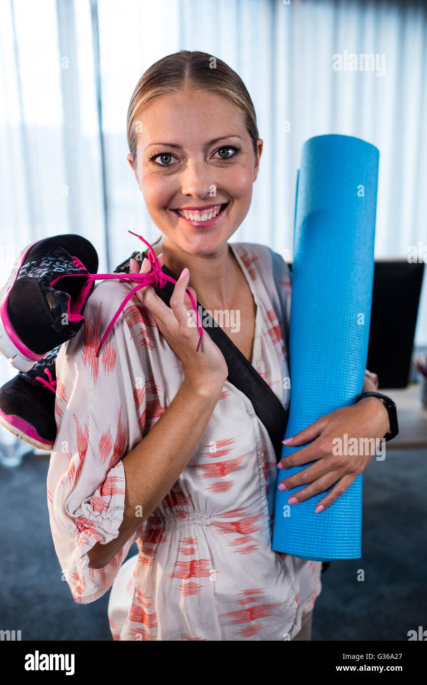 Business casual donna con materassino yoga e calzature sportive Foto Stock