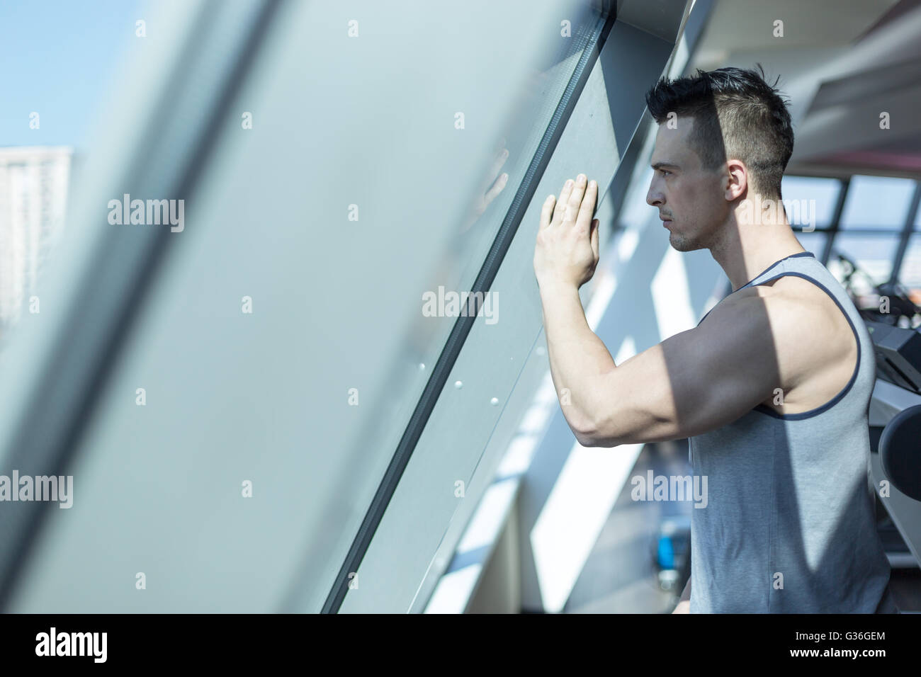 Ritratto di giovane modello fitness training a casa sul tetto Foto Stock