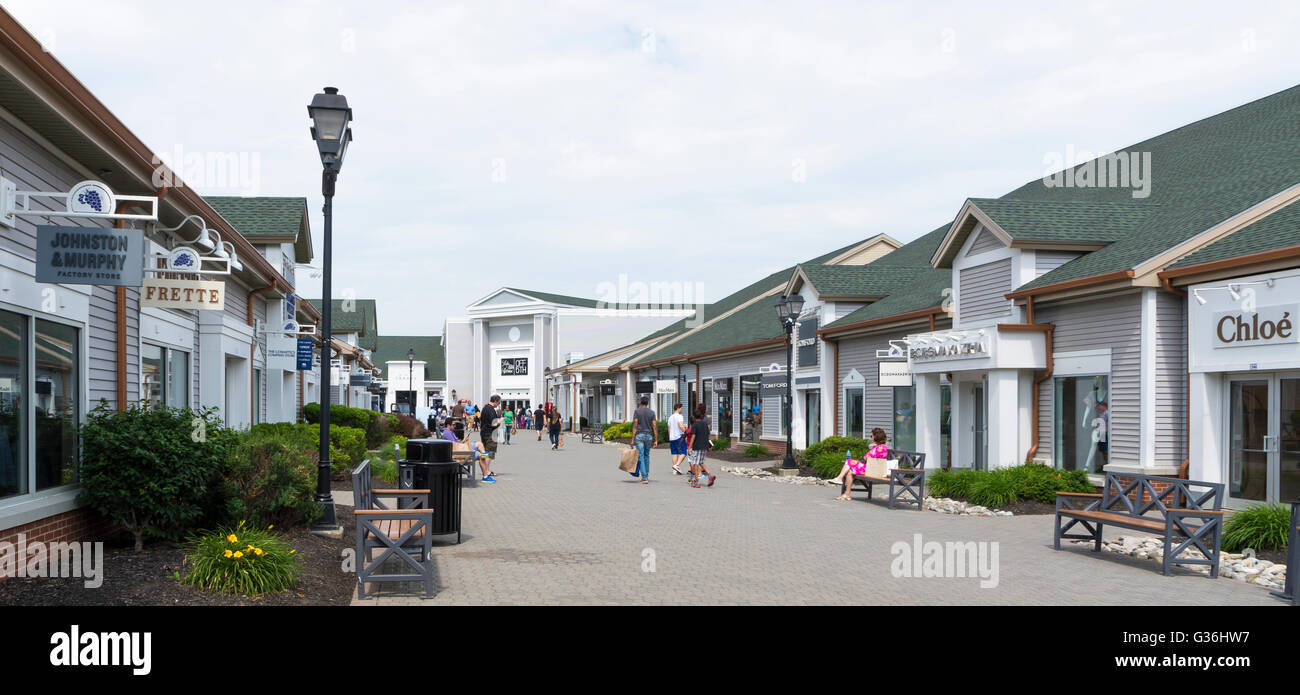 Vista lungo la fila di negozi di design che guarda verso Saks Off quinto al Woodbury Common outlet mall in New York Foto Stock