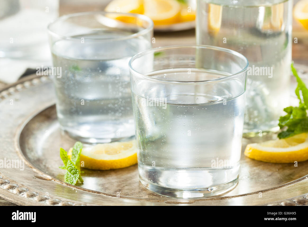 Chiara rinfrescante acqua frizzante con limone e menta Foto Stock
