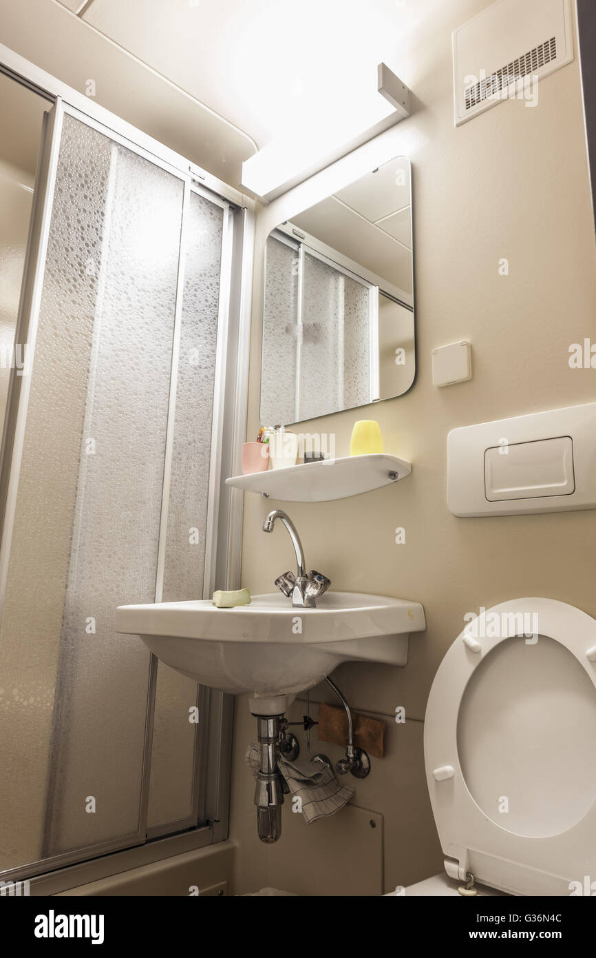 Un piccolo bagno con wc, un lavandino e una cabina doccia Foto Stock Un piccolo bagno con wc, un lavandino e una cabina doccia Foto Stock