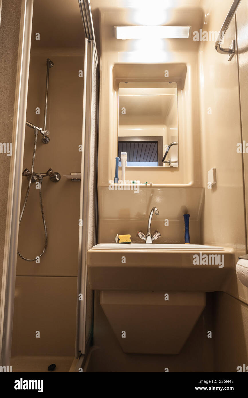 Un piccolo bagno con wc, un lavandino e una cabina doccia Foto Stock Un piccolo bagno con wc, un lavandino e una cabina doccia Foto Stock