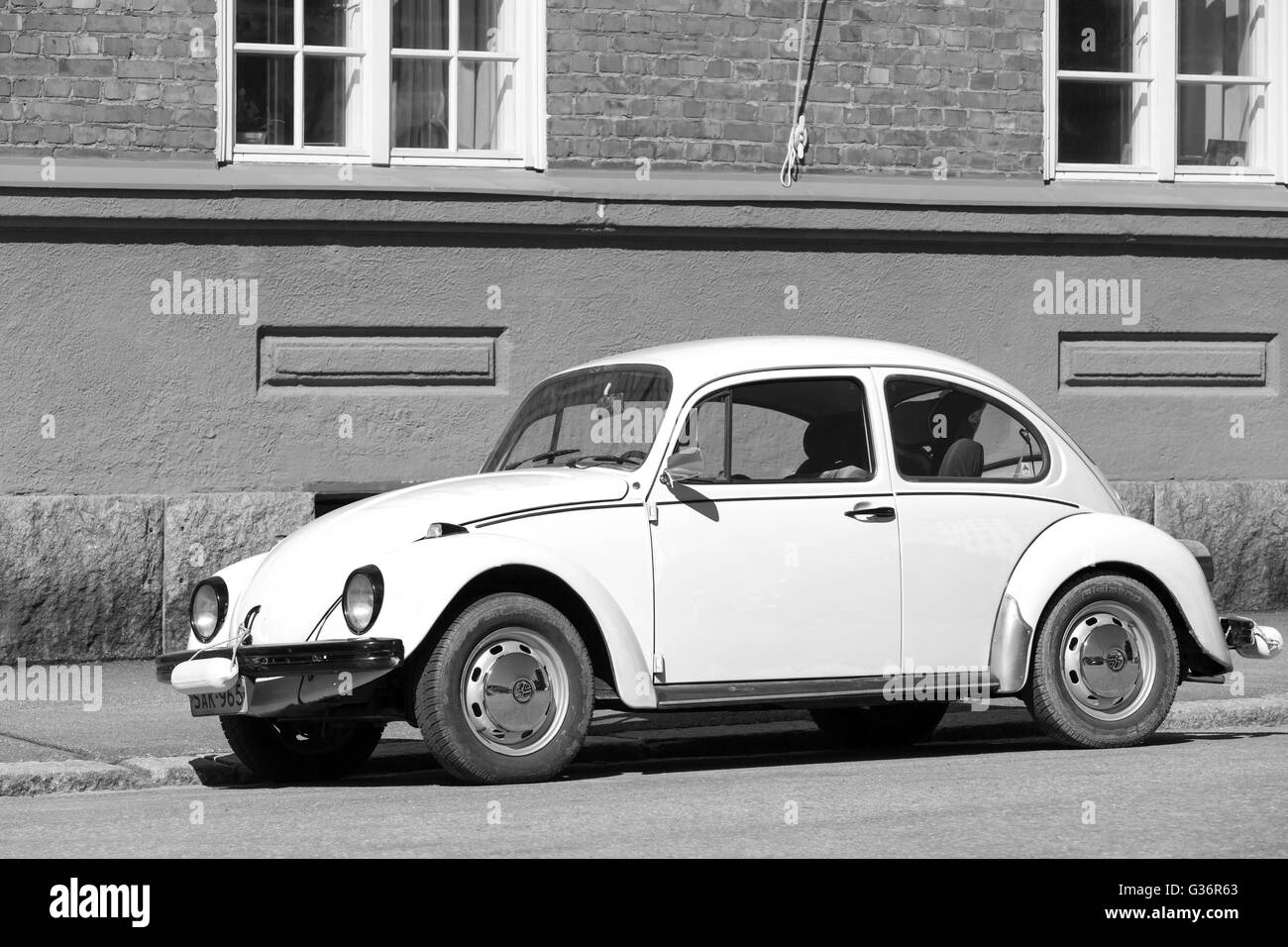 Helsinki, Finlandia - 7 Maggio 2016: il vecchio giallo Volkswagen Beetle è parcheggiato su una strada, in bianco e nero Foto Stock