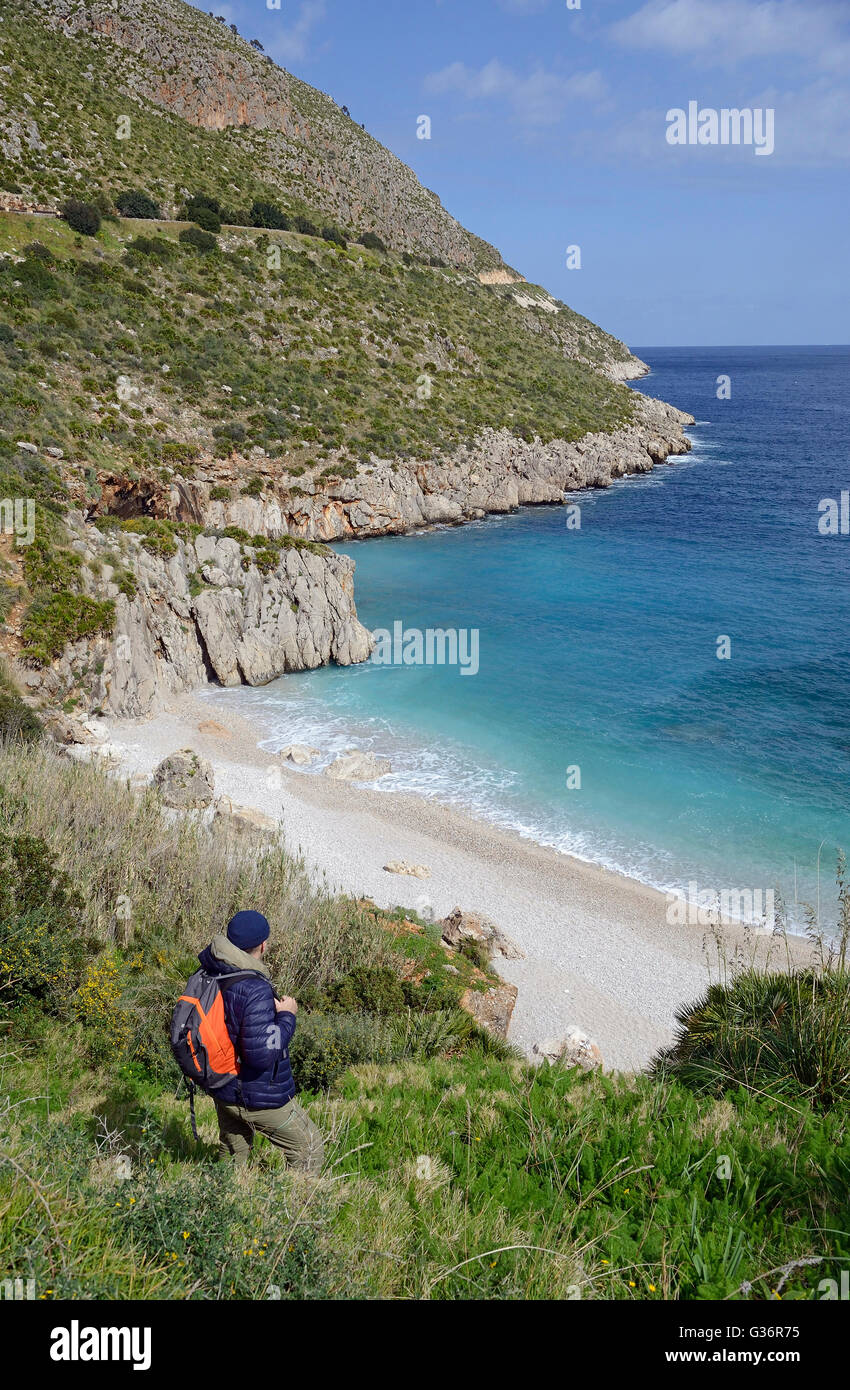 Gli escursionisti su un percorso lungo il mare e la vista Cala Tonnarella dell'Uzzo in riserva dello Zingaro, Sicilia Foto Stock