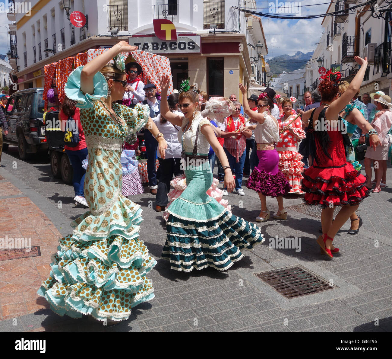 Donne e ragazze vestite con flamenco in costume tradizionale nella strada San Isidro festival fiesta a Nerja Andalusia Spagna Foto Stock