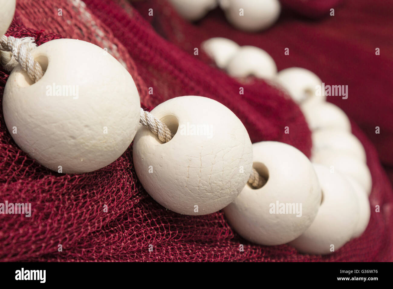 Close up di galleggianti bianchi su rosso drift net Foto Stock