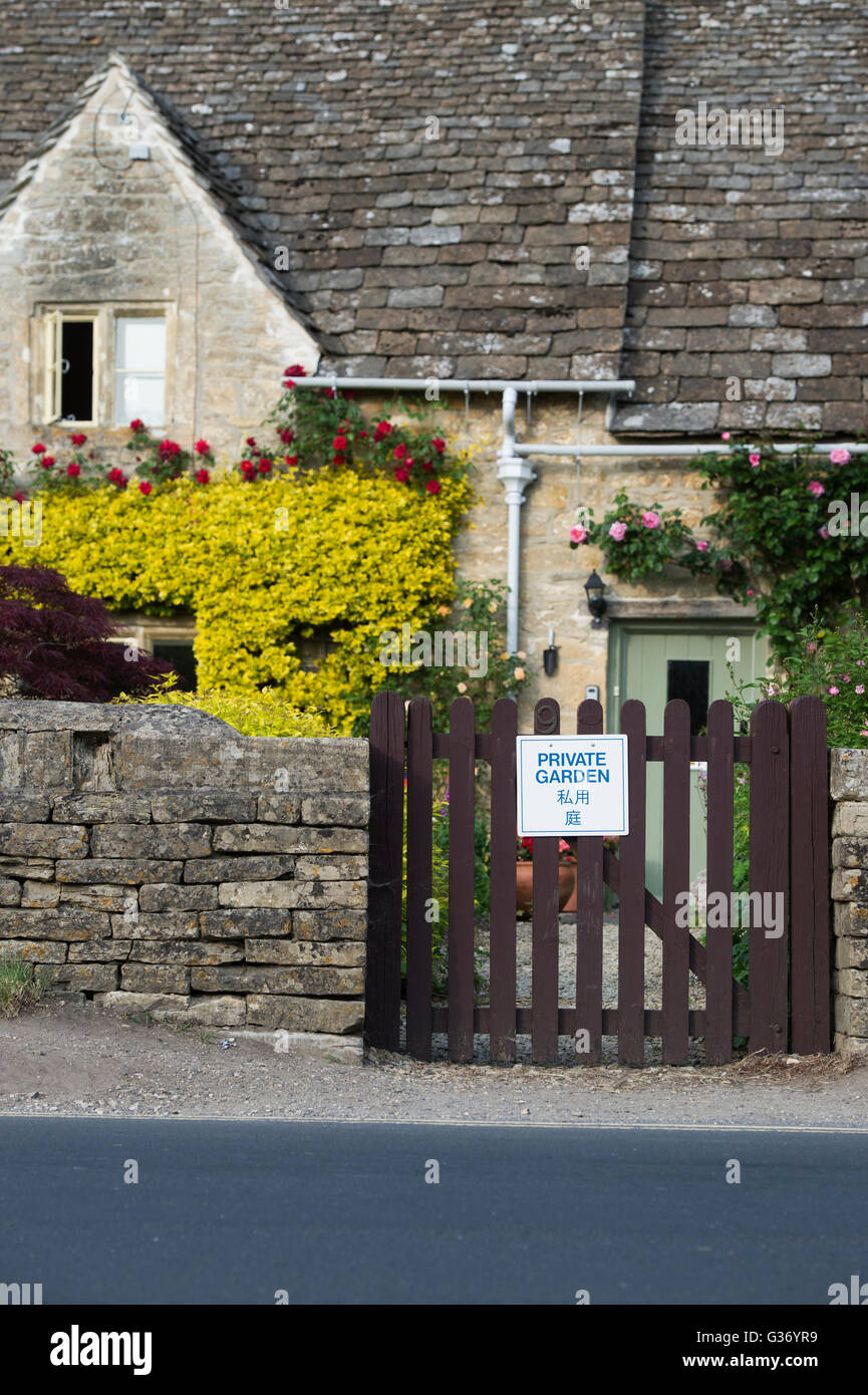 Giardino privato sign in inglese e in cinese sul gate di un cottage a Bibury. Cotswolds, Gloucestershire, Inghilterra Foto Stock