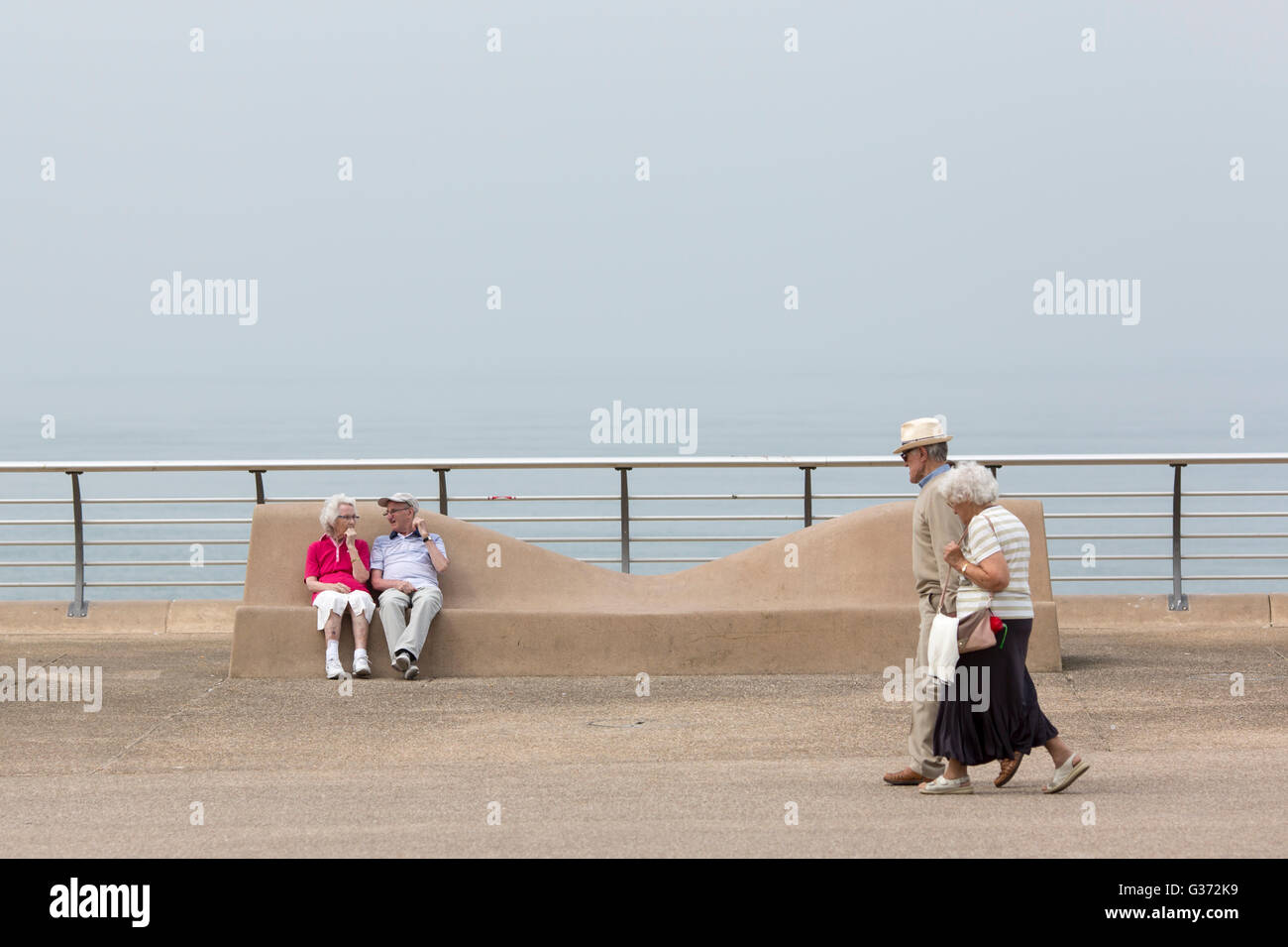 Tempo caldo a Blackpool , Inghilterra.Godersi il caldo sul lungomare.Una coppia di anziani prende una passeggiata Foto Stock