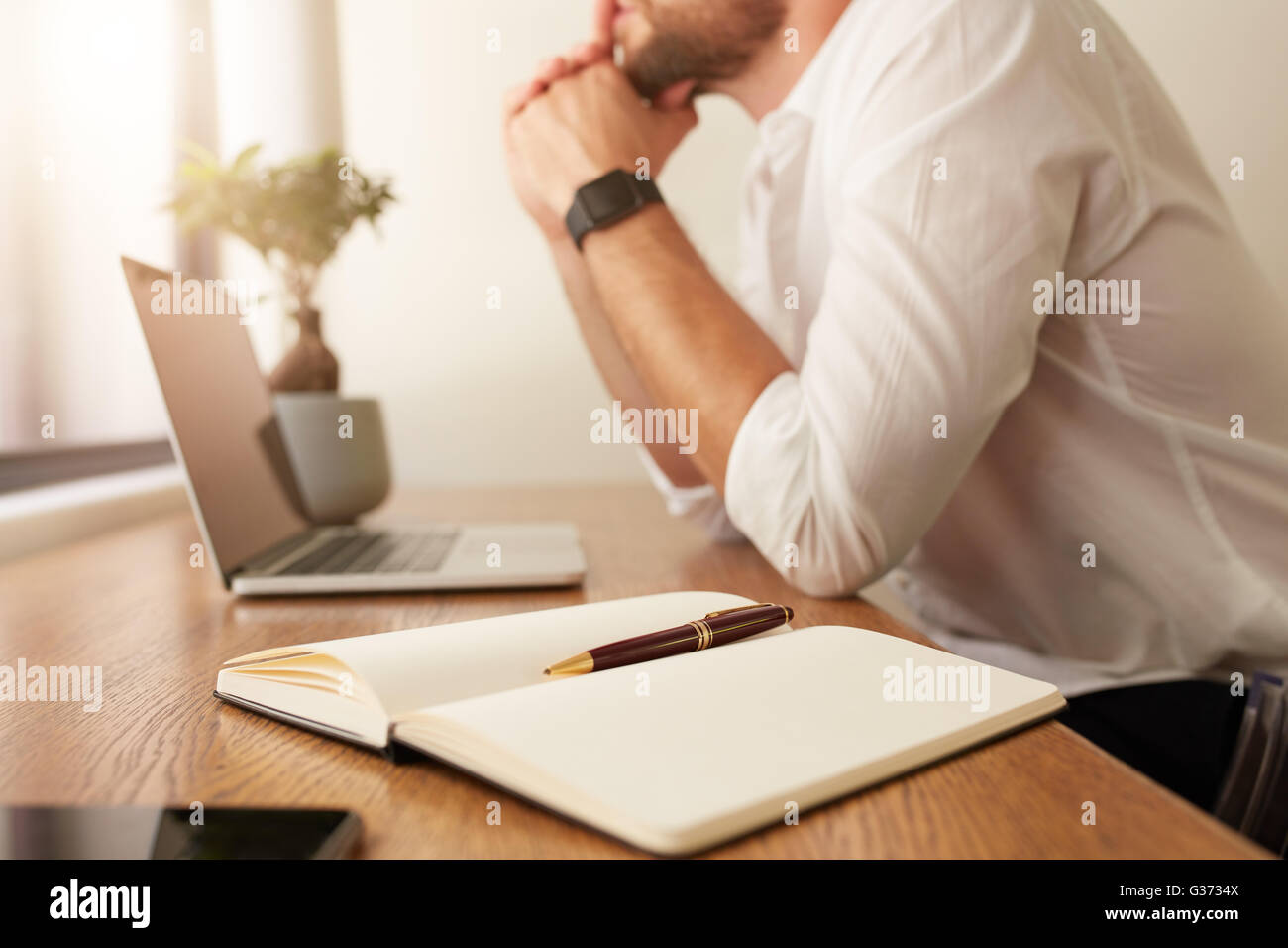 Immagine di agenda elettronica personale sulla tavola con imprenditore  seduto in background. Diario con penna sul tavolo con uomo che lavora  presso la BAC Foto stock - Alamy
