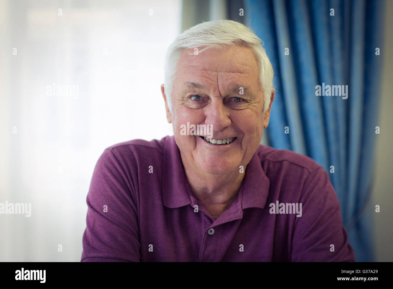 Ritratto di senior uomo seduto in clinica medica Foto Stock